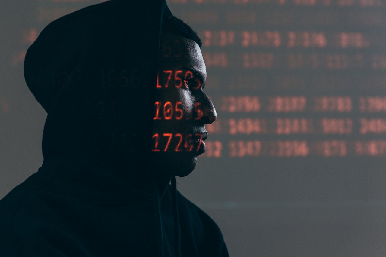 A person's silhouette on a dark background with orange strings of data